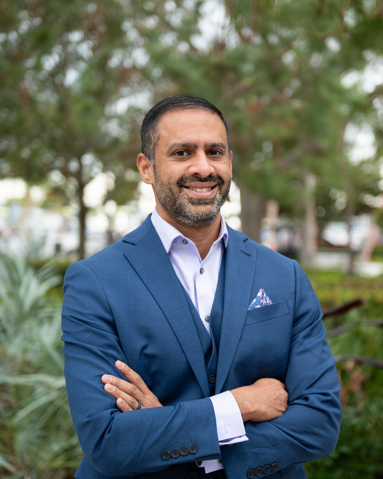 Raveen Shenoi, MD, in a blue suit with arms crossed